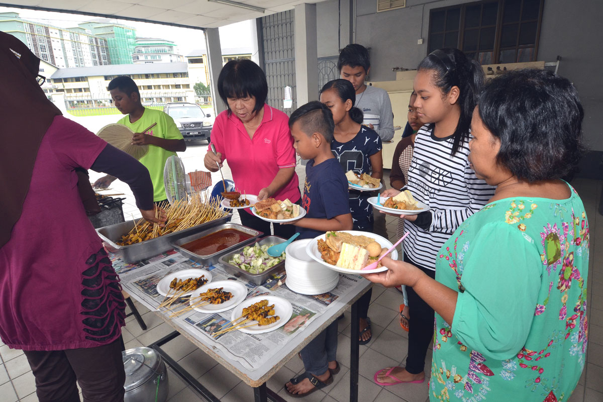 SOA members serve lunch to orang asli at parish hall
