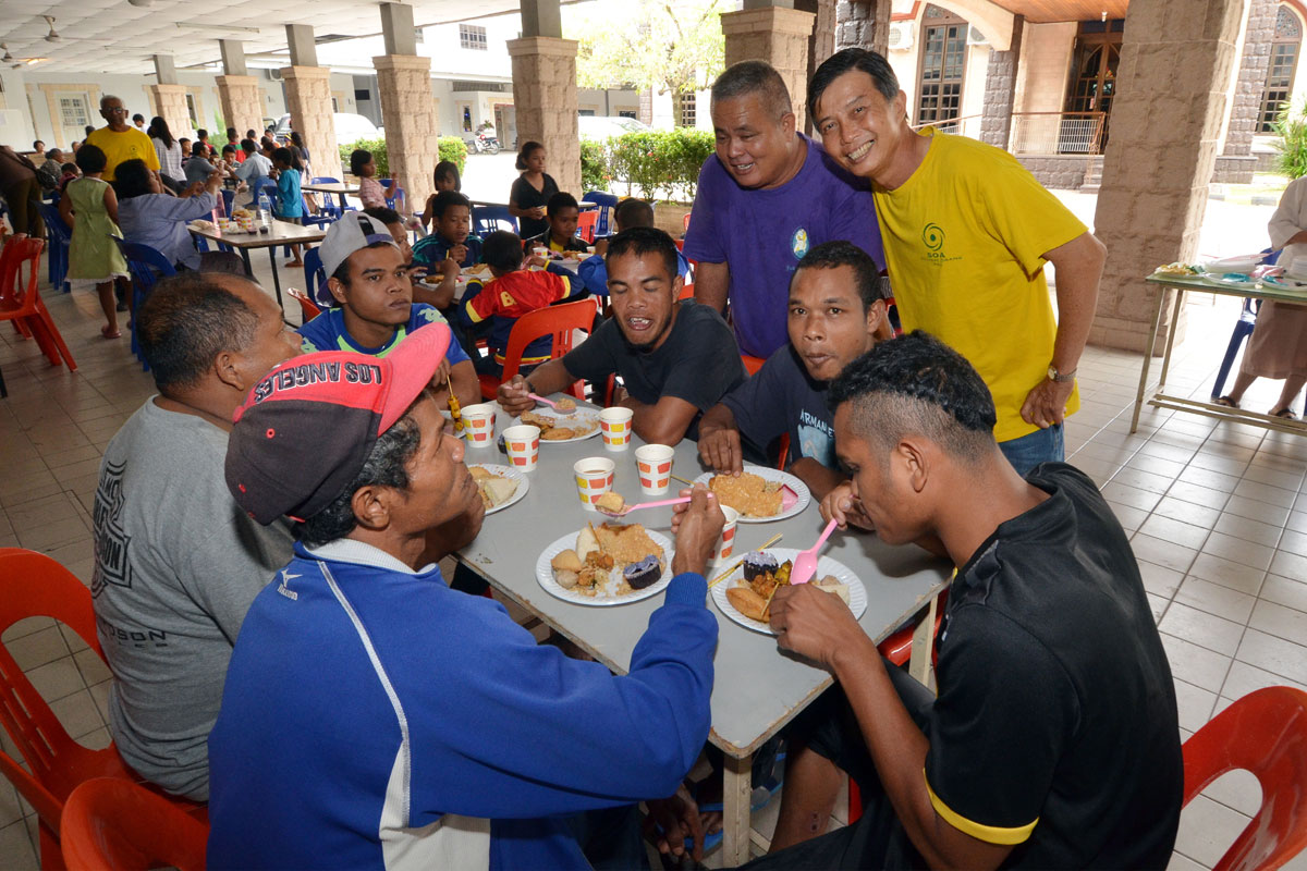 SOA members serve lunch to orang asli at parish hall