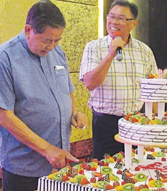 Fr Robin cutting birthday with James Lau